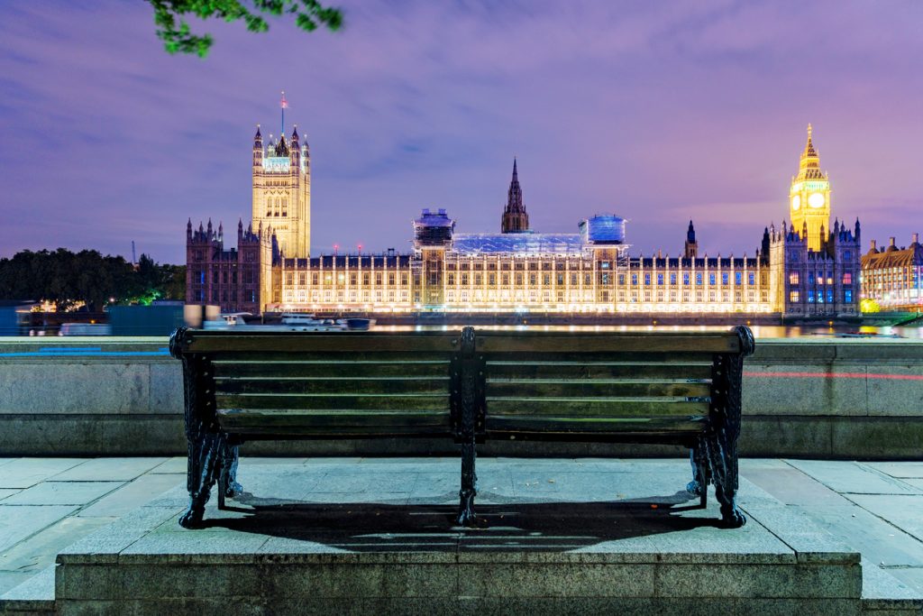 Bench at night with Houses of Parliament in the distance